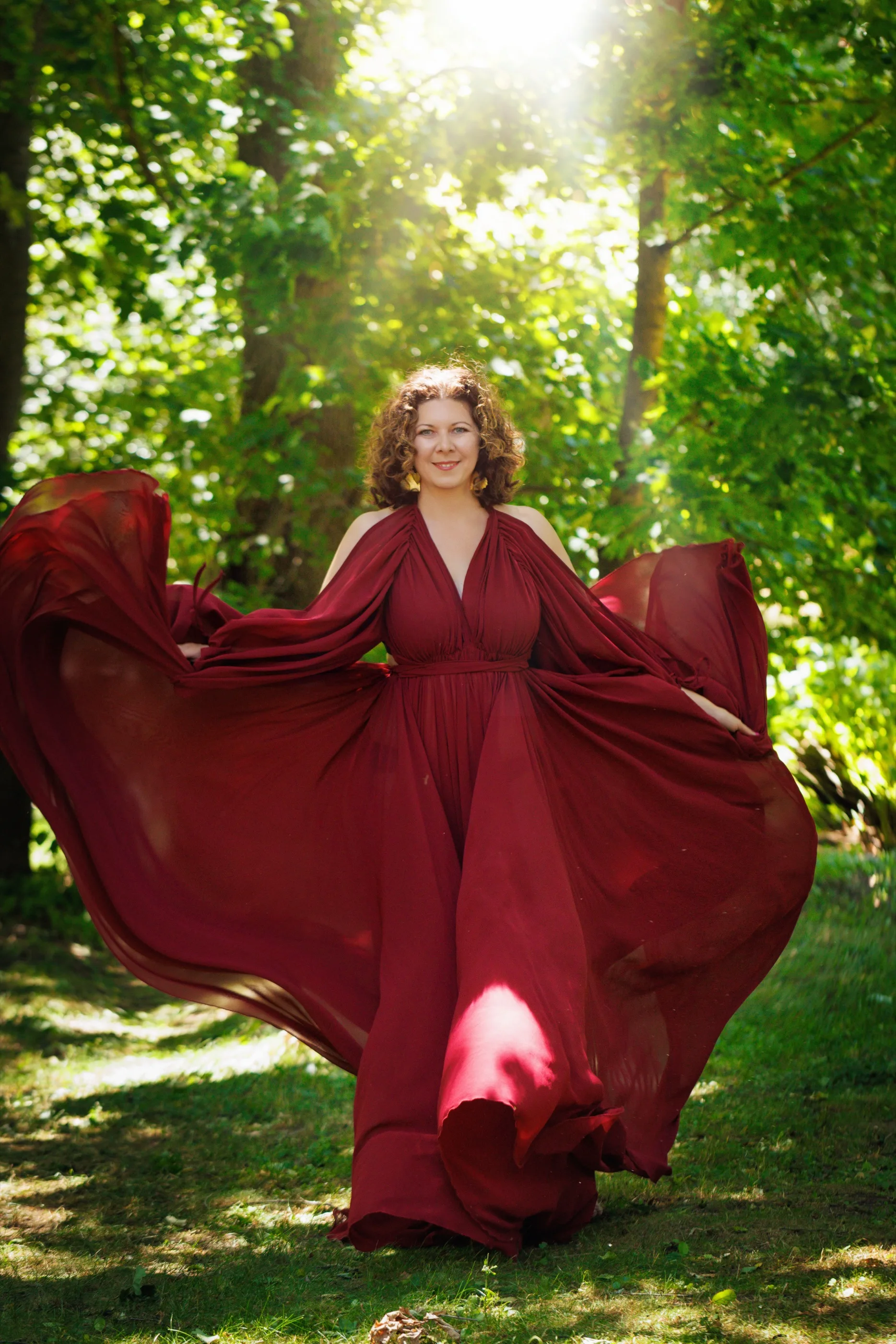 Kamila im roten Kleid im sonnigen Wald